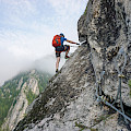 © wirestock | freepik.com | (Stunning shot of a young man climbing up a cliff on a cold and foggy day)